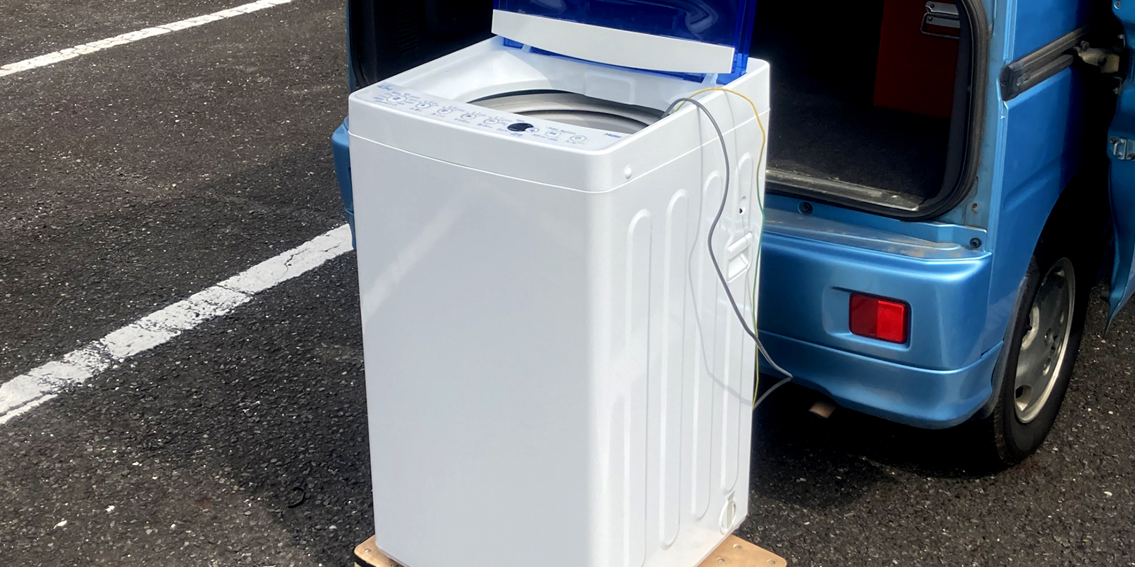 洗濯機を運び出す作業スタッフの様子